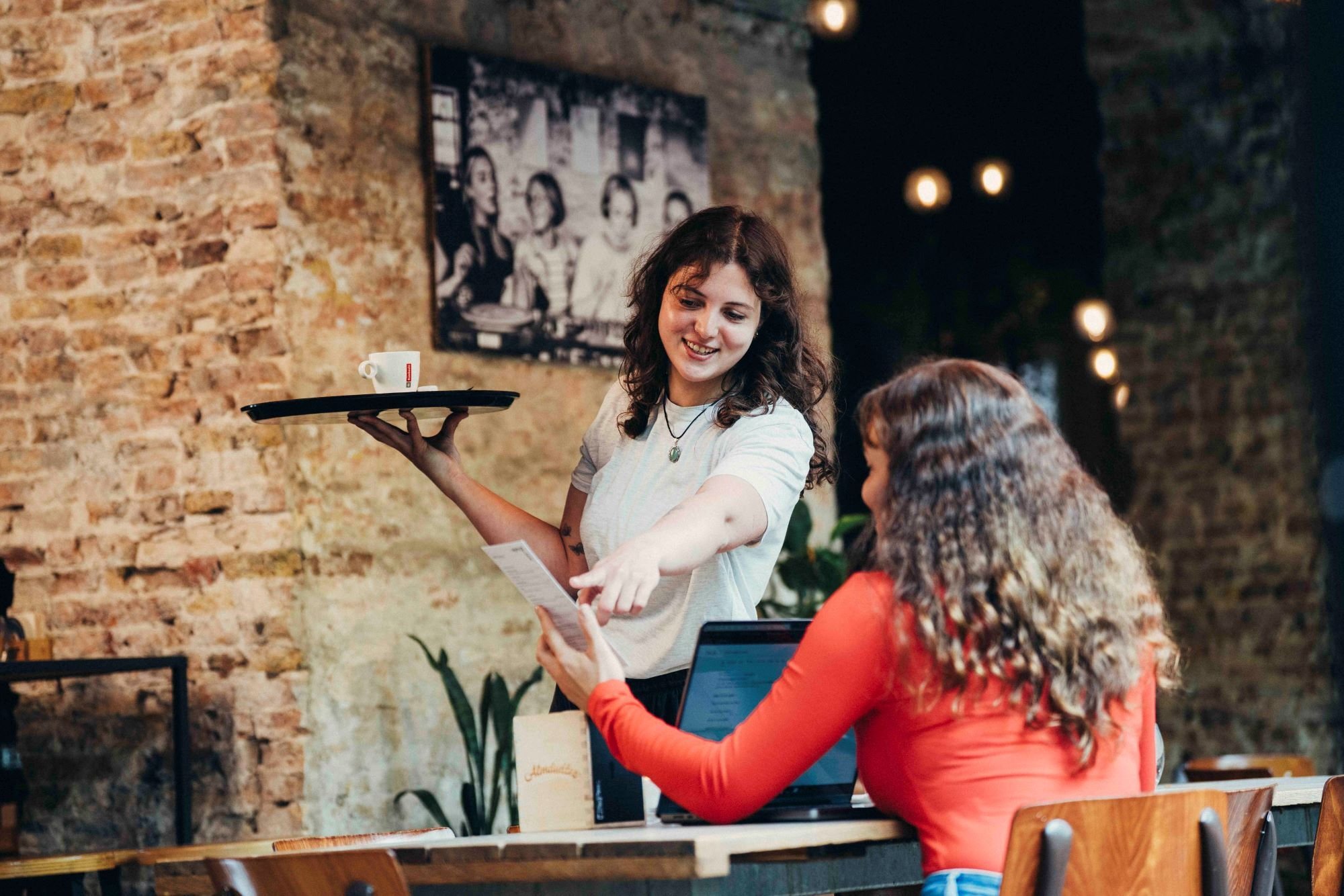 Eigenares koffiezaak geeft uitleg aan klant